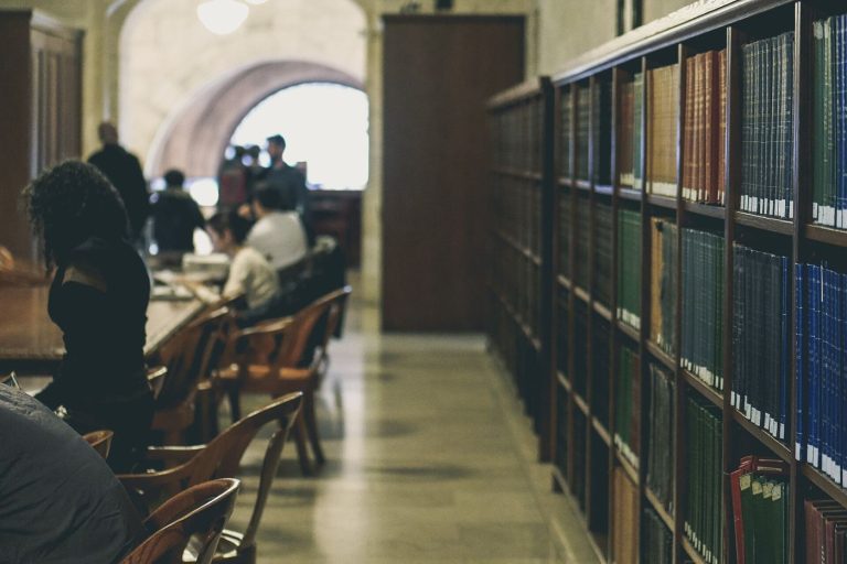 Tall bookshelves in an old library full of enduring books