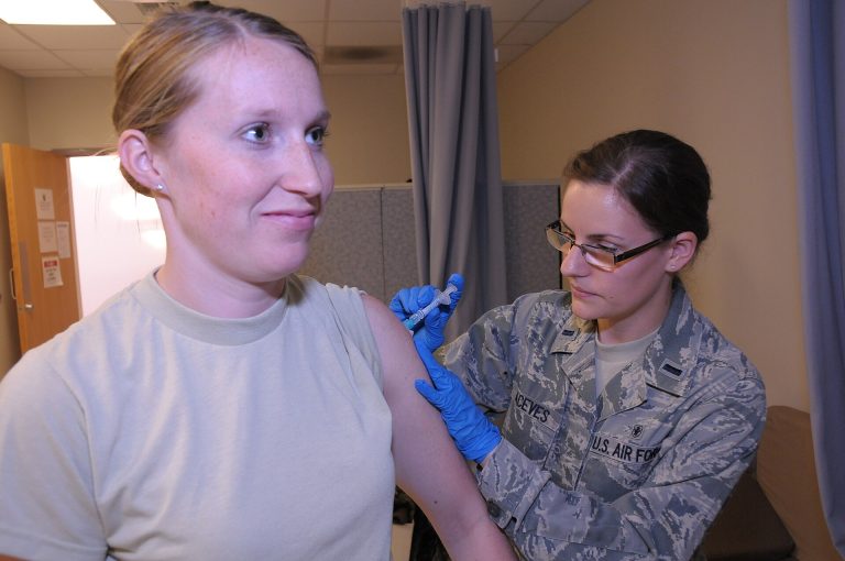 A healthcare worker preparing a measles vaccine dose, illustrating rising US measles cases and vaccination guidance